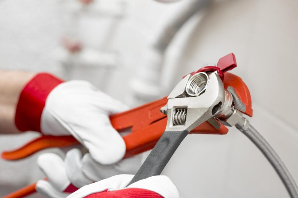 Plumber holding pipe wrenches for an emergency repair in Marietta