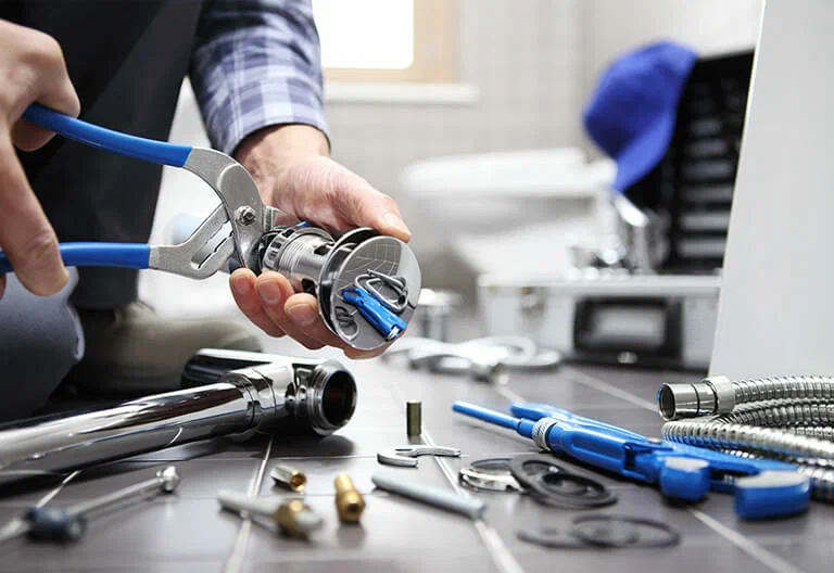 Technician repairing a plumbing fixture with professional tools in Marietta