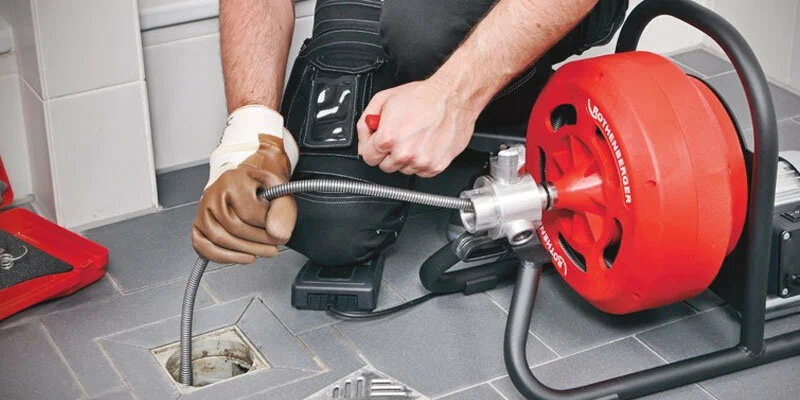 Plumber using a drain-cleaning machine in Marietta