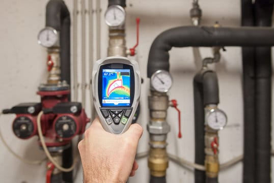 Plumber using a thermal imaging camera to inspect pipes in Marietta